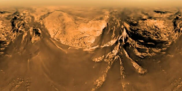 Горная гряда на Титане с высоты 10 км. Метан придаёт атмосфере оранжевую окраску. Снимок зонда Cassini‑Huygens